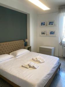 een slaapkamer met een bed met twee handdoeken erop bij Meravigliosa camera con finiture di lusso appena ristrutturata in Marina di Carrara