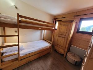 a bedroom with two bunk beds and a window at Appartement Les Gets, 2 pièces, 4 personnes - FR-1-598-44 in Les Gets