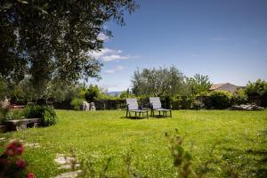 two chairs sitting in the grass in a yard at Casa Rustica 1838 in Sovinjak