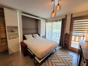 sypialnia z łóżkiem i dużym oknem w obiekcie Appartement Les Gets, 2 pièces, 4 personnes - FR-1-598-142 w mieście Les Gets