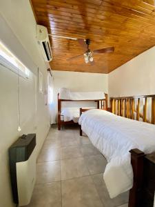 1 dormitorio con 1 cama y ventilador de techo en El Nono en General Alvear