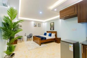 - une chambre avec un lit et des oreillers bleus dans l'établissement Premier Suites Kyanja, à Kampala