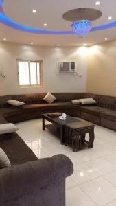 a living room with a couch and a coffee table at شاليه سحاب in Yanbu