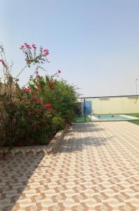 a brick walkway with flowers and a building at شاليه سحاب in Yanbu