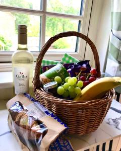 a basket of fruit and a bottle of wine on a counter at Beautiful Shepherd's Hut - Lois Weedon in Weston