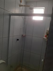 a shower with a glass door in a bathroom at Cantinho da Biu in Maragogi