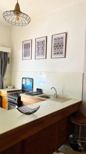 a kitchen with a sink and a counter with a laptop at Charming 1 bedroom house with garden view in Nairobi! in Nairobi