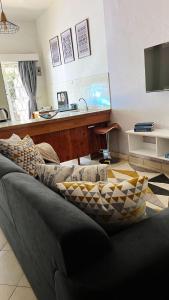 a living room with a couch and a table at Charming 1 bedroom house with garden view in Nairobi! in Nairobi