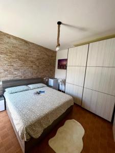 een slaapkamer met een bed en een bakstenen muur bij La bettola di cremia in Cremia