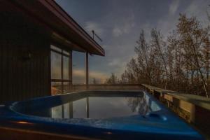 a swimming pool in front of a house at Traditional Cottage with Jacuzzi and Lake View Laugarvatn, Árnessýsla, Islandia in Laugarvatn