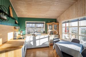 a kitchen with green walls and a wooden ceiling at Traditional Cottage with Jacuzzi and Lake View Laugarvatn, Árnessýsla, Islandia in Laugarvatn
