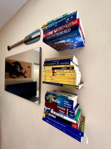 una pila di libri su un muro accanto a uno specchio di La bettola di cremia a Cremia