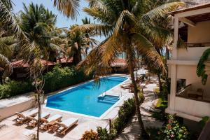 an overhead view of a swimming pool with palm trees at Petit Lafitte Beach Front Hotel & Bungalows in Playa del Carmen