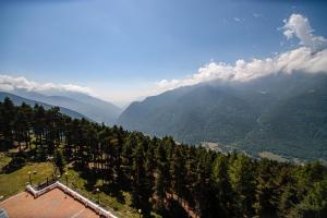 vista su una valle di montagna con alberi e montagne di Pràcatinat Hotel & Restaurant a Fenestrelle