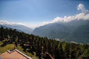 uma vista para um vale montanhoso com árvores e montanhas em Pràcatinat Hotel & Restaurant em Fenestrelle