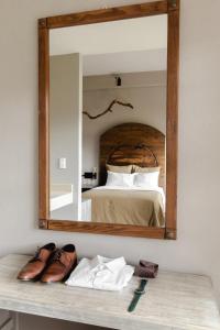 espejo en la pared con cama en el dormitorio en Hotel Rocaval San Cristóbal de las Casas en San Cristóbal de Las Casas