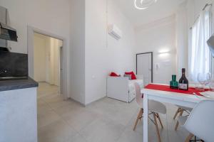 a white kitchen with a table and a dining room at PALAZZO DUCALE - Romantico appartamento in centro in Modena