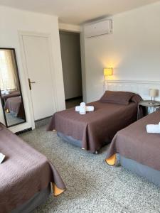 a hotel room with two beds and a mirror at Hotel L'Illa in Tossa de Mar