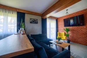 a living room with a blue couch and a wooden table at Wolfpack Guest House in Białka Tatrzańska
