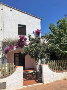 un edificio bianco con recinzione e fiori viola di Casa en Palamós (Costa Brava). Unifamiliar, 3 BDRM, 6 Pers, Garage a Palamós