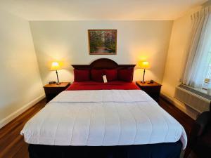 a bedroom with a red and white bed with two lamps at Inn at Cemetery Hill in Gettysburg