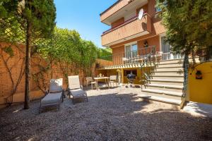 a patio with two chairs and a table in front of a house at CASA CON PISCINA EN EL CENTRO in Tudela