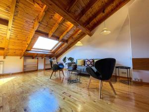 a living room with wooden ceilings and a couch and chairs at Casa Elegancia Pleta de Saga in Ger