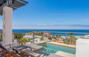 a balcony with a swimming pool and the ocean at Villa Solnordal with Panoramic Pacific View in Cabo San Lucas