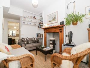 a living room with wicker chairs and a fireplace at 7 Bell Street in Talgarth