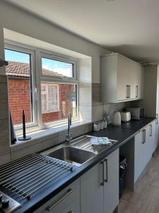 cocina con fregadero y ventana en A new built brick chalet en Leysdown-on-Sea