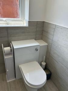 a bathroom with a white toilet and a window at A new built brick chalet in Leysdown-on-Sea