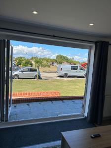 a view from a window of a parking lot at A new built brick chalet in Leysdown-on-Sea