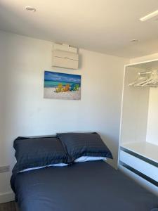 a bed in a bedroom with a painting on the wall at A new built brick chalet in Leysdown-on-Sea
