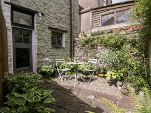 a table and chairs in a garden next to a building at 7 Bell Street in Talgarth