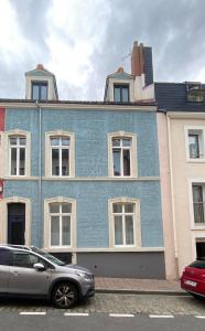 un edificio blu con una macchina parcheggiata di fronte di Les loges du théâtre Monsigny a Boulogne-sur-Mer