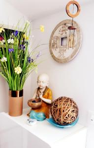 una muñeca sentada en un estante junto a un jarrón con flores en PaKua apartments & Penthouse with 2 terraces, en Rovinj