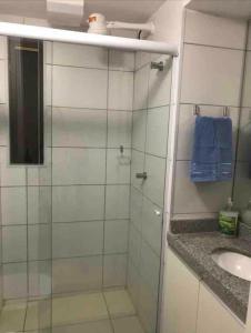 uma casa de banho com uma cabina de duche em vidro e um lavatório. em Flat 402 Laguna Beach - tipo Loft encantador, mobiliado e aconchegante em Porto de Galinhas
