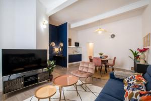 a living room with a blue couch and a table at Hirondelle de Montpellier in Montpellier
