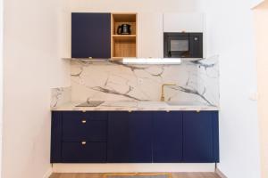 a kitchen with blue cabinets and a marble counter top at Hirondelle de Montpellier in Montpellier