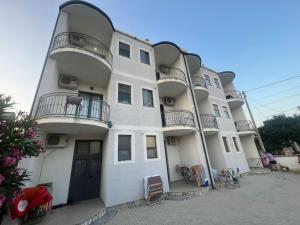 un edificio blanco con balcones en un lateral en Sar Hotel, Velipojë, en Velipojë