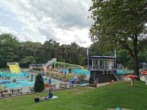 un parque acuático con piscina y gente en él en Chalet de Blauwe regen en Balkbrug