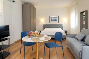 une chambre d'hôtel avec un lit, une table et des chaises dans l'établissement Ancora Suites, à Bardolino