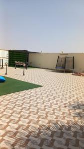 a patio with a tiled floor with a table and benches at شاليه سحاب in Yanbu