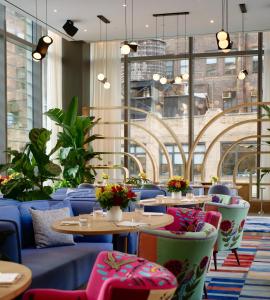 un restaurante con mesas y sillas y una gran ventana en Virgin Hotels New York City, en Nueva York
