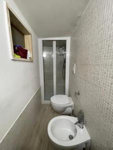 a white bathroom with a toilet and a sink at Cinzia’s Home in Lecce