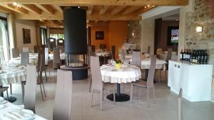 MénillesにあるDomaine de la Haie des Grangesの白いテーブルと椅子、暖炉のあるレストラン