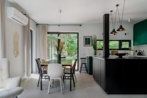 a kitchen and dining room with a table and chairs at Domek z basenem nad Bugiem in Błonie