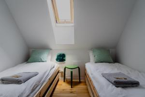 2 camas individuales en una habitación con ventana en Domek z basenem nad Bugiem, 