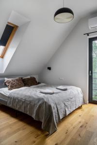 a white bedroom with a bed and a window at Domek z basenem nad Bugiem in Błonie