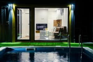 a house with a swimming pool in front of a window at MILUX in Sanski most